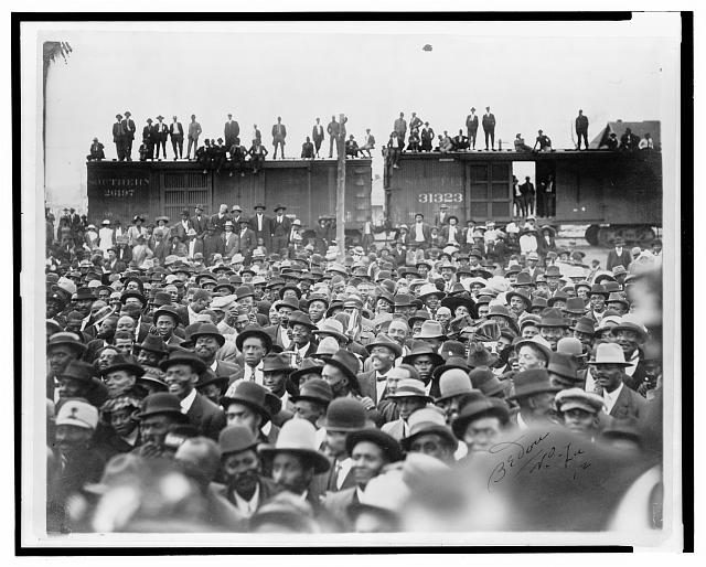 [Large crowd gathered to hear Booker T. Washington speak, with men standing on railroad box cars in the background, New Orleans, Louisiana]